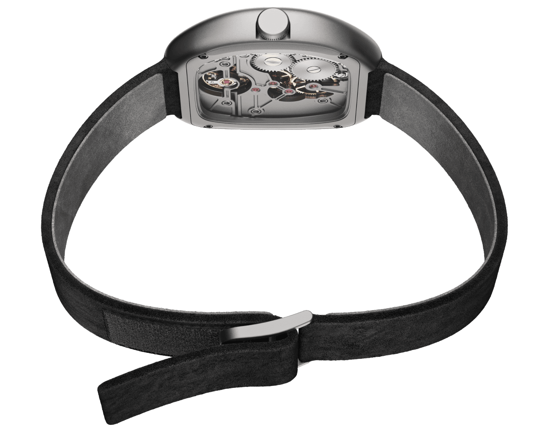 Rear view of a skeleton mechanical watch with a cushion-shaped titanium case, exposing the movement through a transparent caseback. Ruby jewels, a large gear train, and machined bridges are visible. The watch sits on a black suede strap with a polished folding clasp, photographed against a white background.